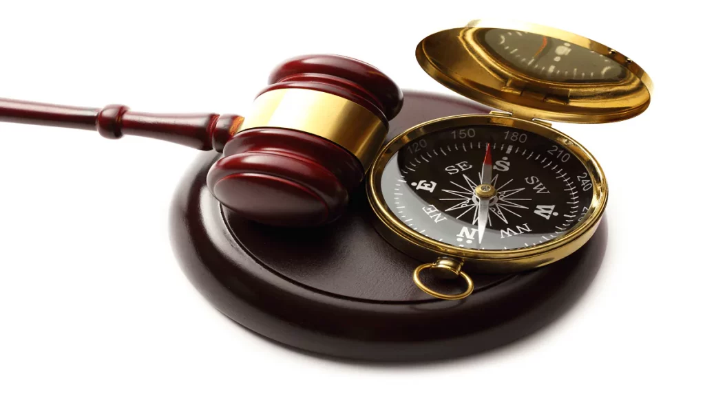 Martelo de juiz com bússola em fundo branco