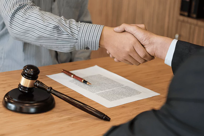 Advogado e cliente apertando as mãos em escritório